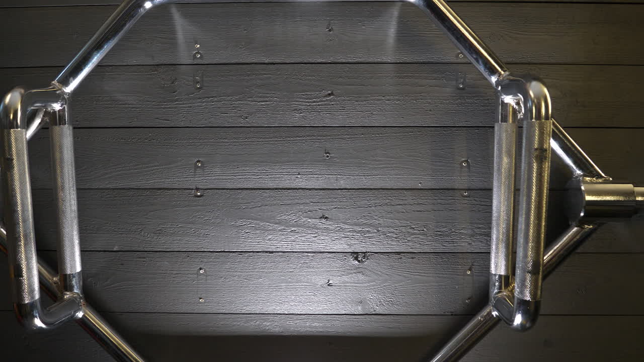 hexbar, también llamado trapbar, colgado en la pared de un gimnasio