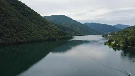 aerial forward scenic panorama view of lake veliko plivsko jajce, road with cars