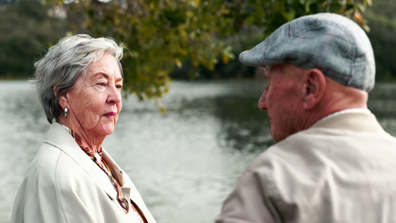 Elderly couple embracing by the lake