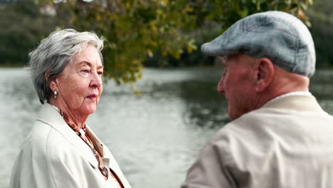elderly couple embracing by the lake