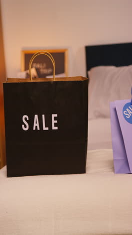 sale shopping bags on a bed