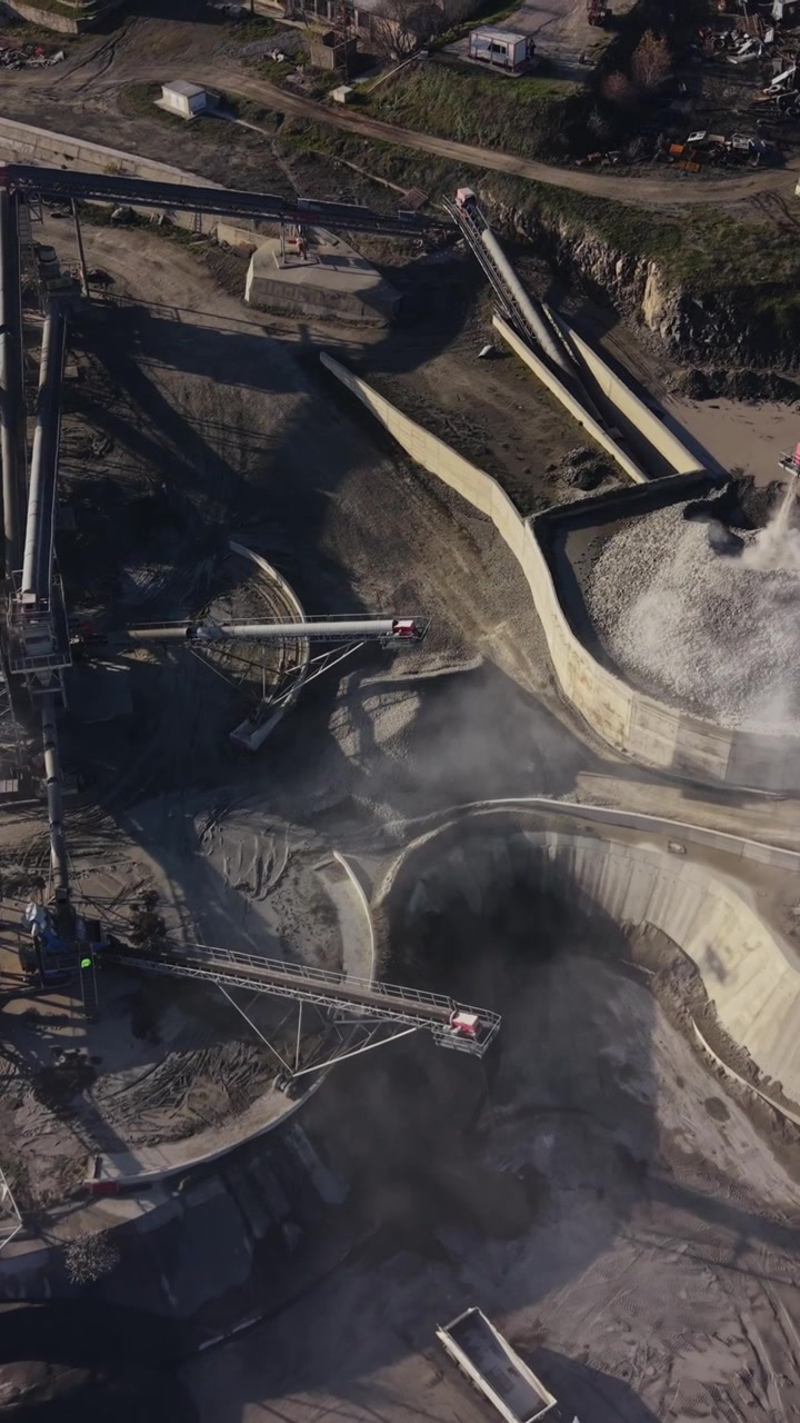 Mining operations at a quarry with trucks and machinery in motion
