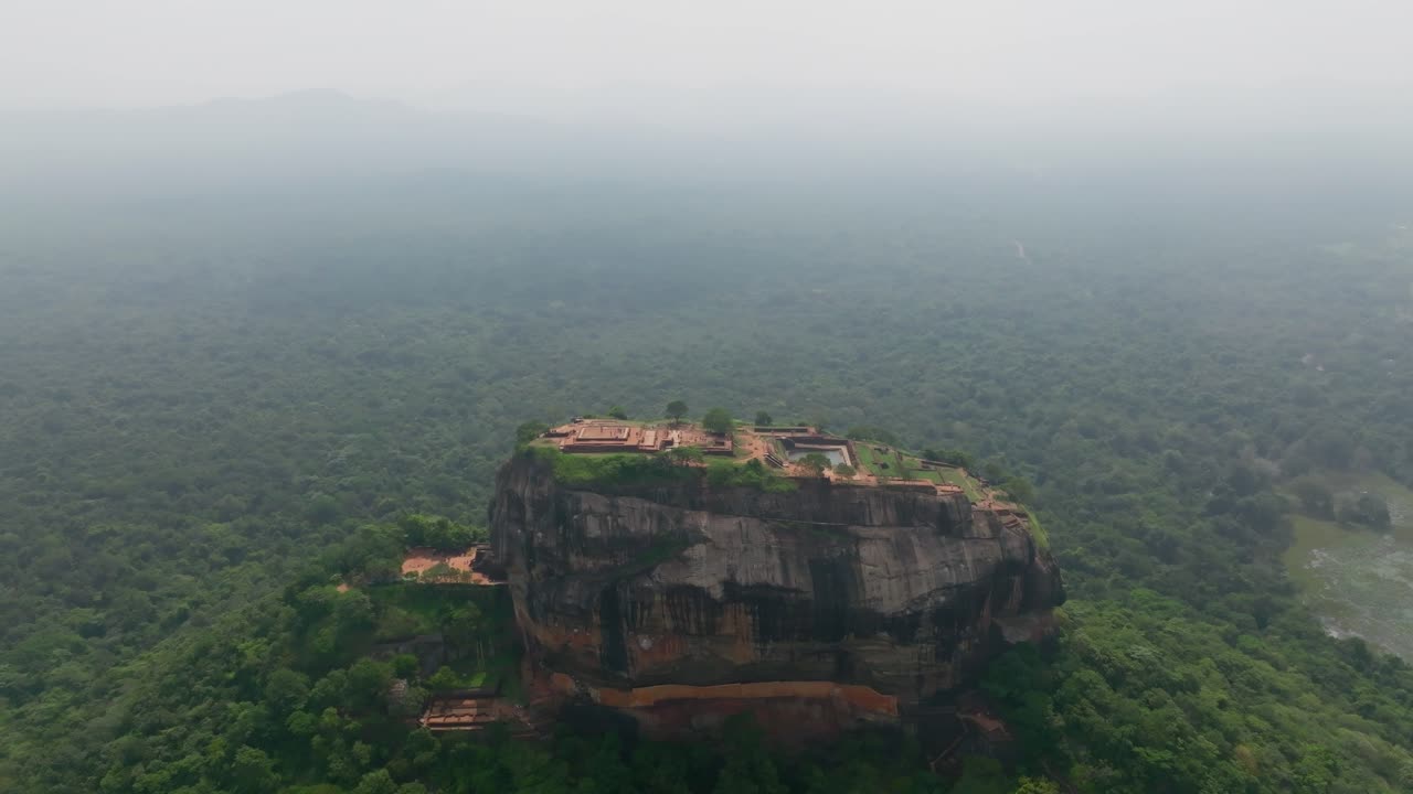 Orbita di un drone sopra Sigiriya Rock Fortress, in Sri Lanka, che mostra le rovine della vetta piatta sullo sfondo di una vasta giungla all'orizzonte