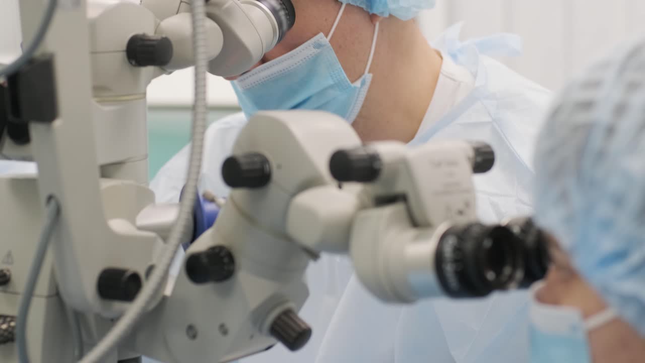 Equipe chirurgica che esegue un intervento chirurgico per strabismo utilizzando tecnologie moderne, dispositivi all'avanguardia, microscopio in una clinica moderna
