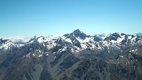 cámara lenta: montañas rocosas cubiertas de nieve en el parque nacional de aoraki mountain cook, alpes del sur, nueva zelanda desde un vuelo panorámico en avión