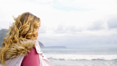 woman standing with her bicycle on beach