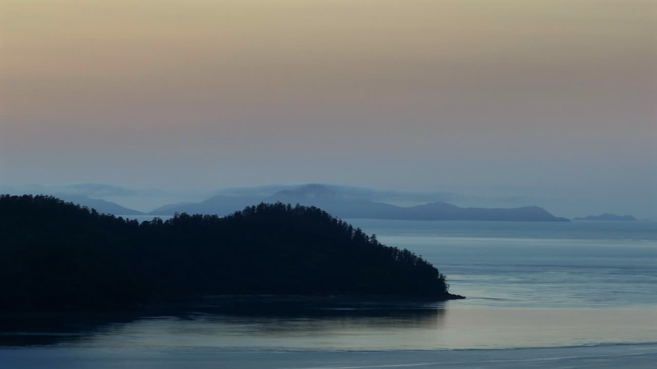 Aerial: Drone shot of pine forested island during the early dawn in Whitsunday islands, QLD, Australia