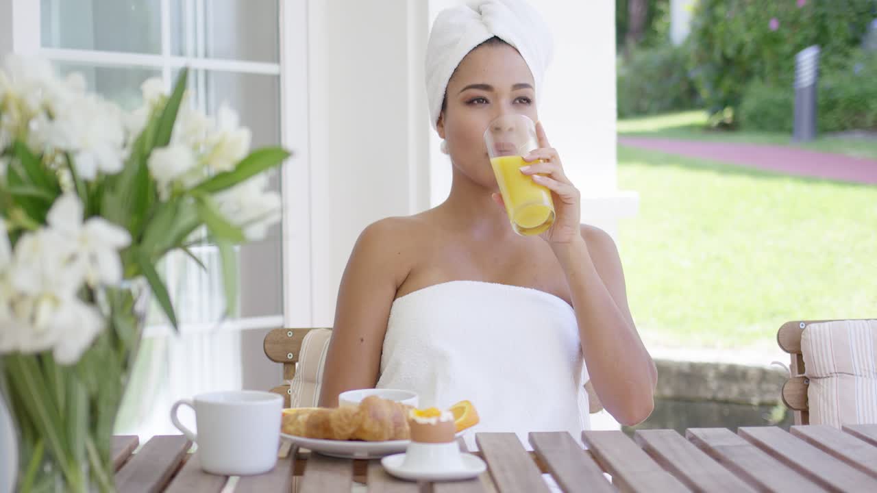 아침 식사를 하는 수건 에 싸여 있는 미소 짓는 여자