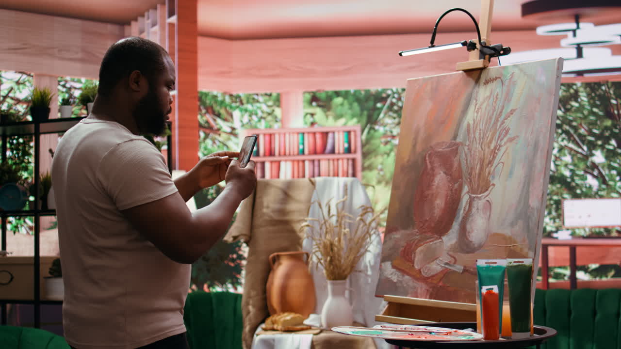 An artist taking pictures of his still life painting in a studio