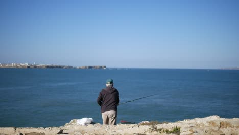 a local peniche fisherman throwing the hook