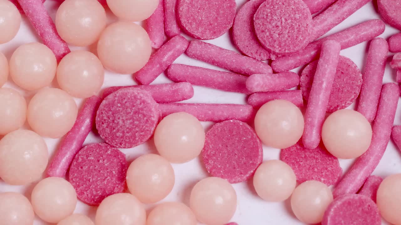 Macro view of pink and peach sprinkles cascading in slow motion, creating a vibrant and playful visual effect