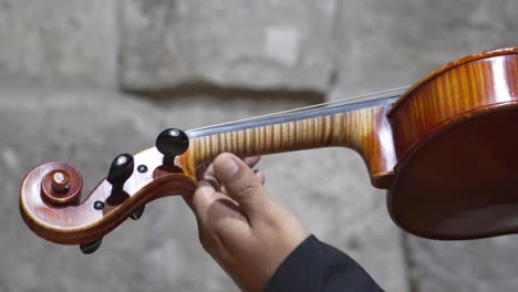 hand and fingers of violinist on fingerboard, technique of playing violin, close up