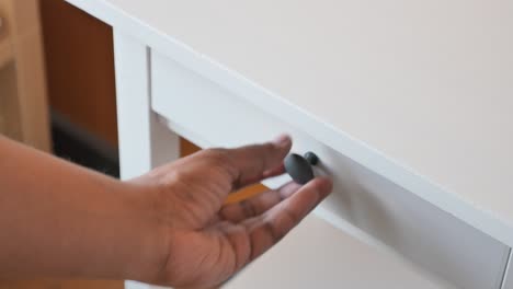 white desk with open drawer and hand