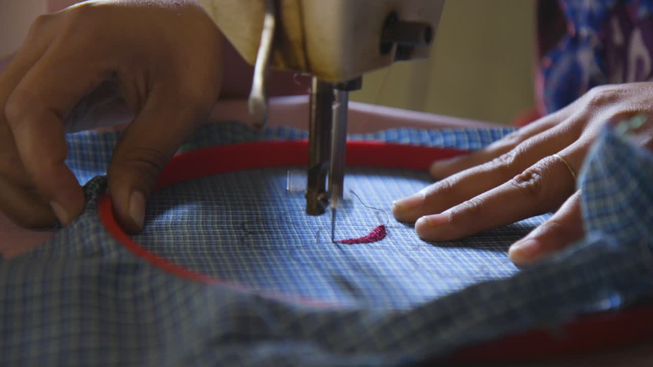 una mujer bordando un diseño de flores en un delantal tradicional en san miguel del valle en oaxaca, méxico