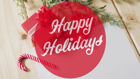 animation of happy holidays text over christmas decorations background