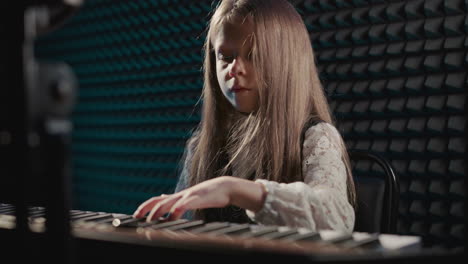 young girl playing piano in music studio