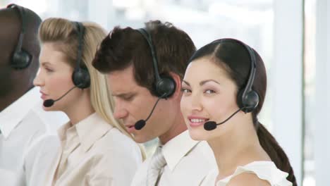 Business-team-with-headphones-one-woman-smiling