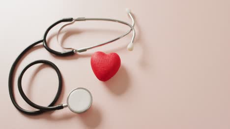 Video-of-close-up-of-stethoscope-with-heart-on-pink-background