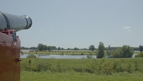 panning over beautiful dutch landscape, revealing old cannon aimed at river