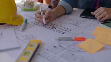 close up hands architects using building plans business women working together on construction project team of engineers brainstorming design solution planning successful development strategy