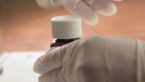 abrir el frasco de medicamentos con guantes de higiene disparo de cerca