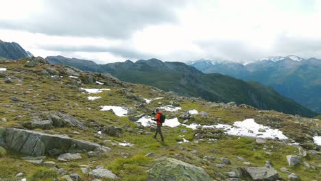 excursionista vlogging con una cámara entre las montañas