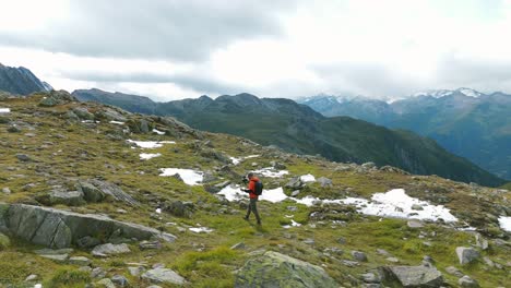 hiker vlogging with a camera between mountains