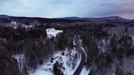 Drone-Vuela-A-Lo-Largo-De-Un-Camino-Sinuoso-En-Las-Montañas-Nevadas-De-Vermont-Durante-La-Puesta-De-Sol