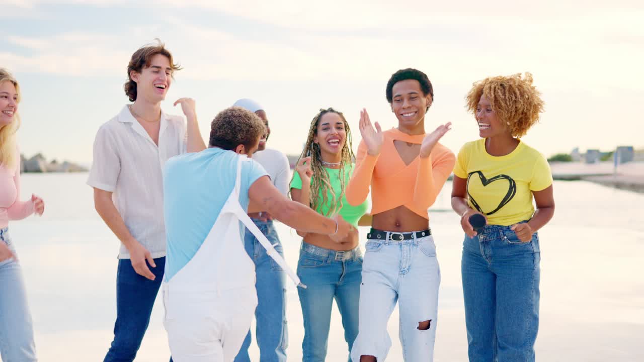 Multi-ethnic friends turning to dance freestyle next to the sea