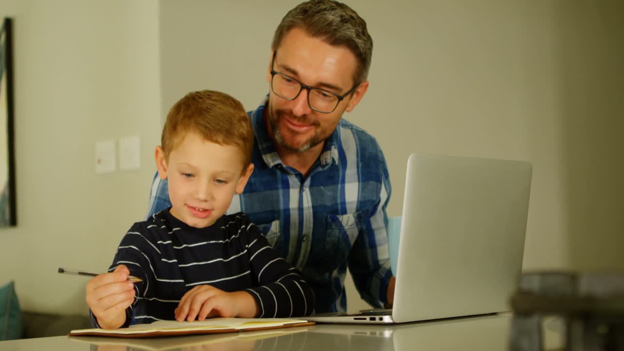 padre viendo a su hijo haciendo la tarea en la mesa 4k