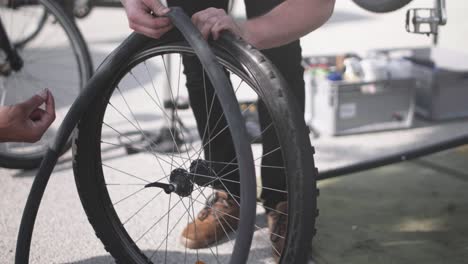 a bike wheel being equiped with a new tube by a bike mechanic