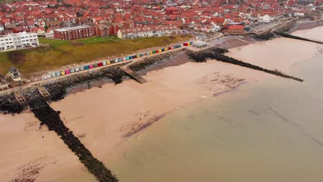 Aerial---Coast,-seawall,-and-North-Sea,-Sheringham,-England,-wide-forward-shot