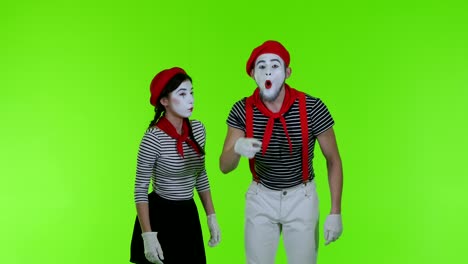 surprised mimes look at the camera on a green background