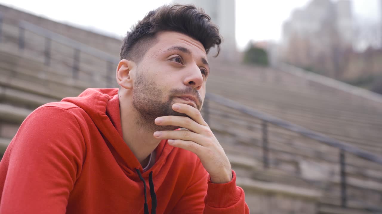 el hombre que está solo en la ciudad está en pensamientos pesados, cuestionando la vida, desesperado.