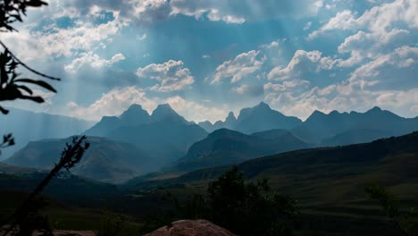 4k lapso de tiempo de sol brillando a través de las nubes en la majestuosa montaña del pico de la catedral de drakensberg en sudáfrica