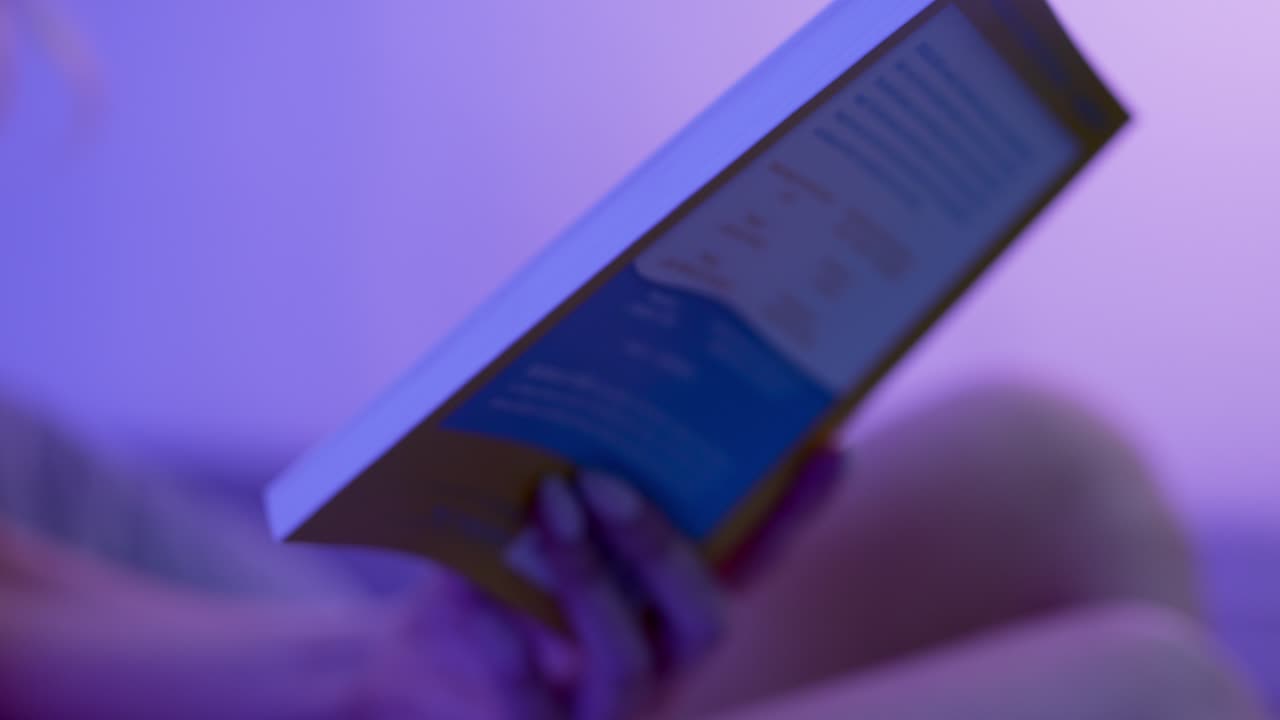 primer plano de una mujer desnuda sosteniendo un libro y ajustando la posición