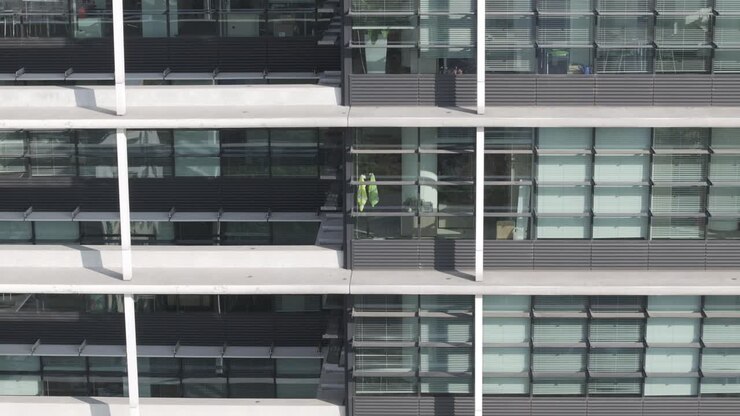 Ascending drone shot of skyscraper's windows with balconies