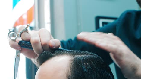 barbero profesional peinando el cabello. peluquero haciendo peinado con peine