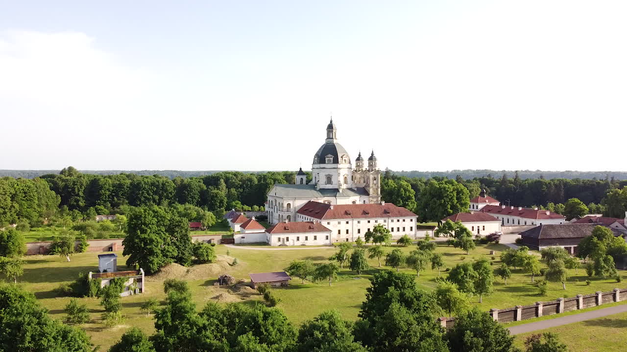 edificio del complejo del monasterio de pazaislis con cúpula majestuosa en descenso detrás de la vista de drones de arbustos