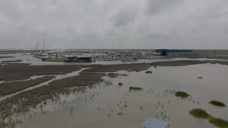 Aerial-approach-to-a-busy-Cove-harbor-Marina-in-Rockport,-Texas-on-a-cloudy-day