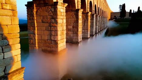 ancient aqueduct in fog at sunrise