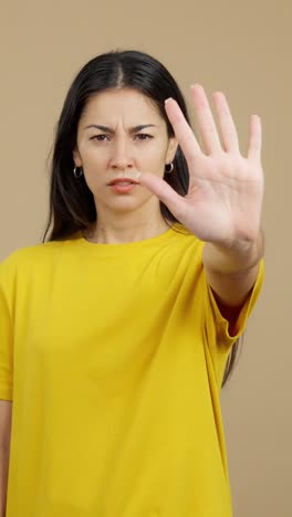 woman showing a stop gesture with a serious expression