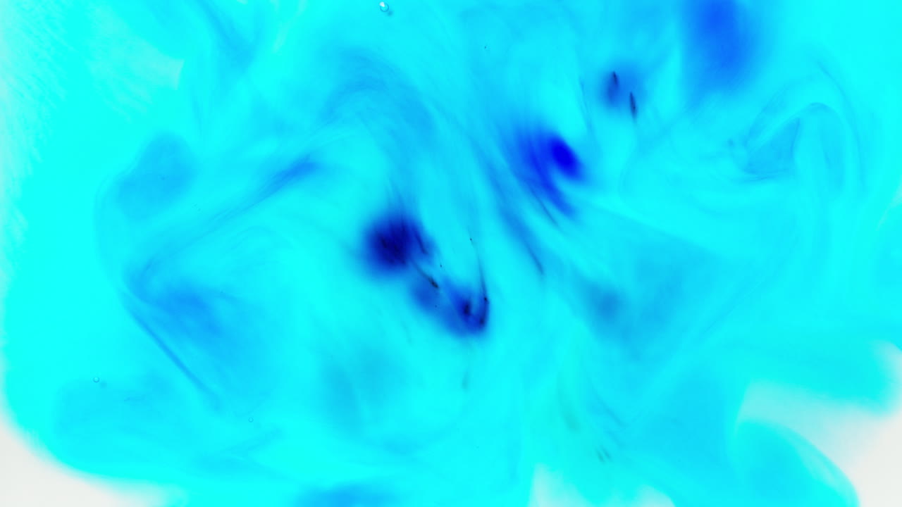 pintura o tinte turquesa y azul caído en el agua contra un fondo blanco para crear un fondo de humo de colores giratorios 1