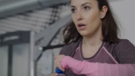 Handheld-view-of-tired-woman-catching-a-short-break-during-exercising-in-gym