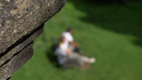 Defocused-Shot-of-Two-People-Sat-On-Public-Park-Bench-In-Oxford