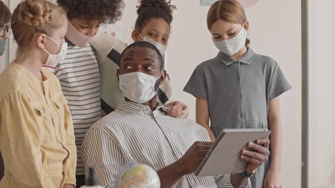 Teacher Explaining New Topic to Children Using Tablet