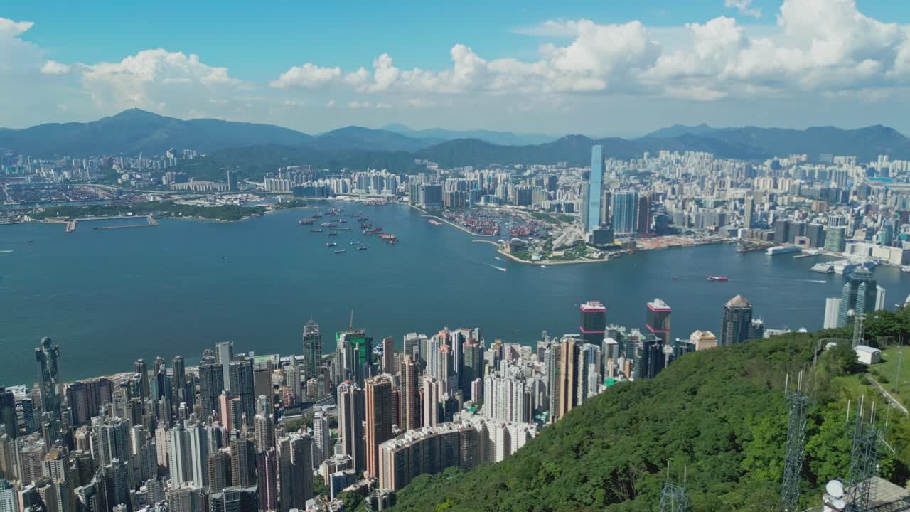 Aerial drone footage capturing Hong Kong harbour with city skyline, bustling vessels, and waterfront views, highlighting maritime transport, urban architecture, and iconic coastal landscapes
