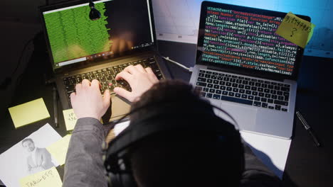 top shot of caucasian man in headphones typing on laptop keyboard