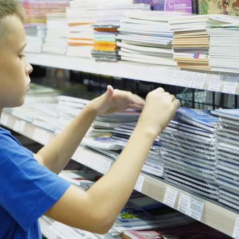 vinnitsa, ukraine - august, 2018: boy chooses office supplies. many colorful tools and supplies on the shelf of a stationery shop