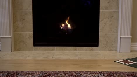 vintage toy train with engine and caboose being pulled across the floor in front of a fireplace